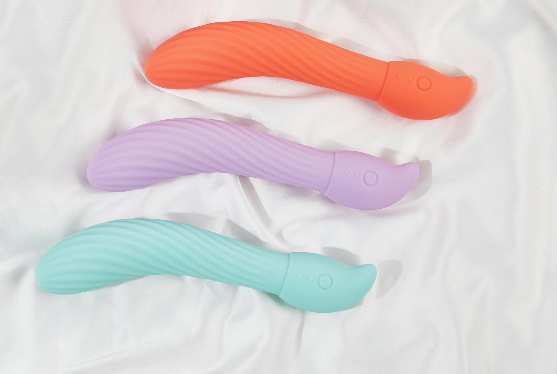 A stylish teal lemon clitoral vibrator on smooth white silk fabric.