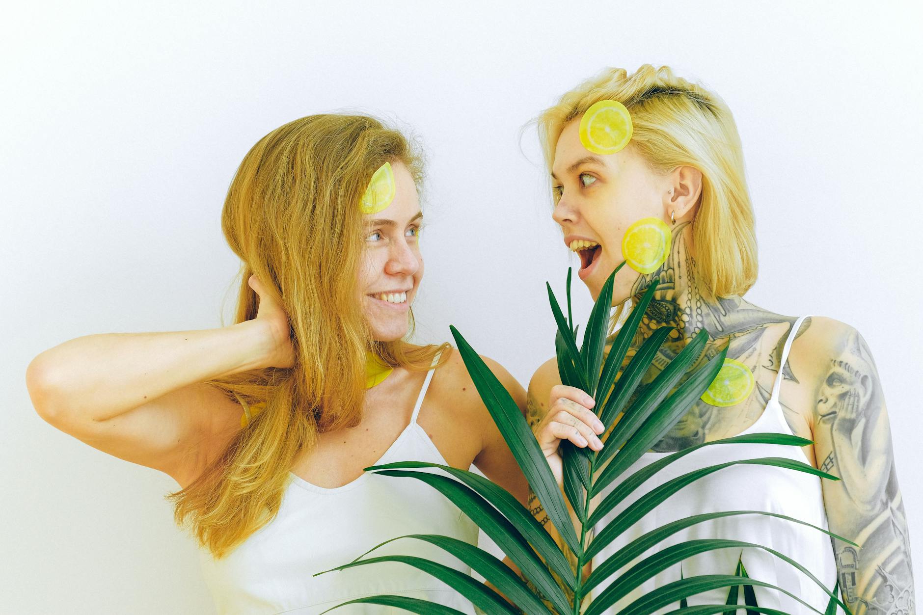 Two women smiling together with lemon props, expressing joy and connection