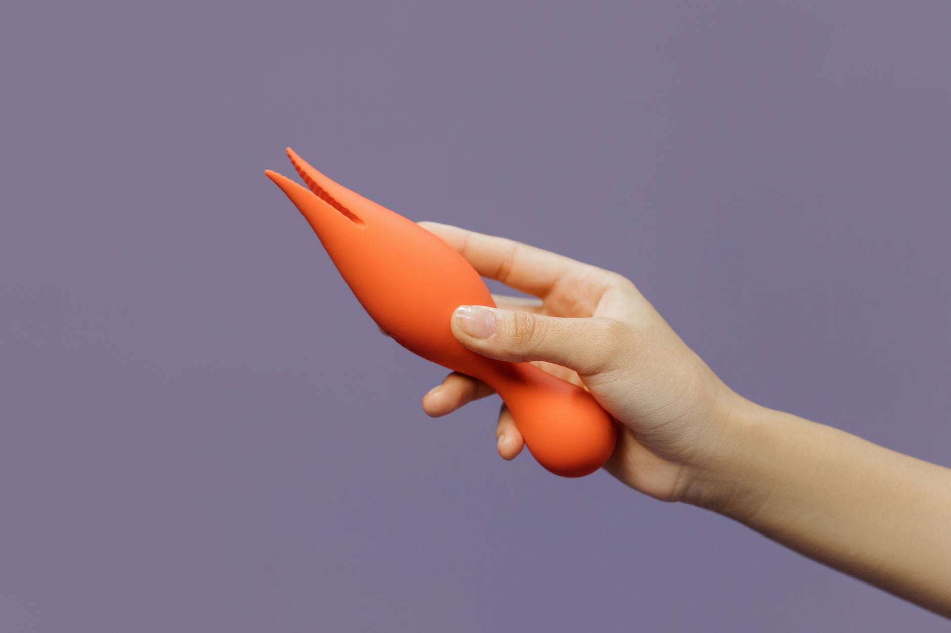 A hand holding a lemon-colored vibrator against a minimalist purple backdrop, representing reclaimed autonomy and healing.