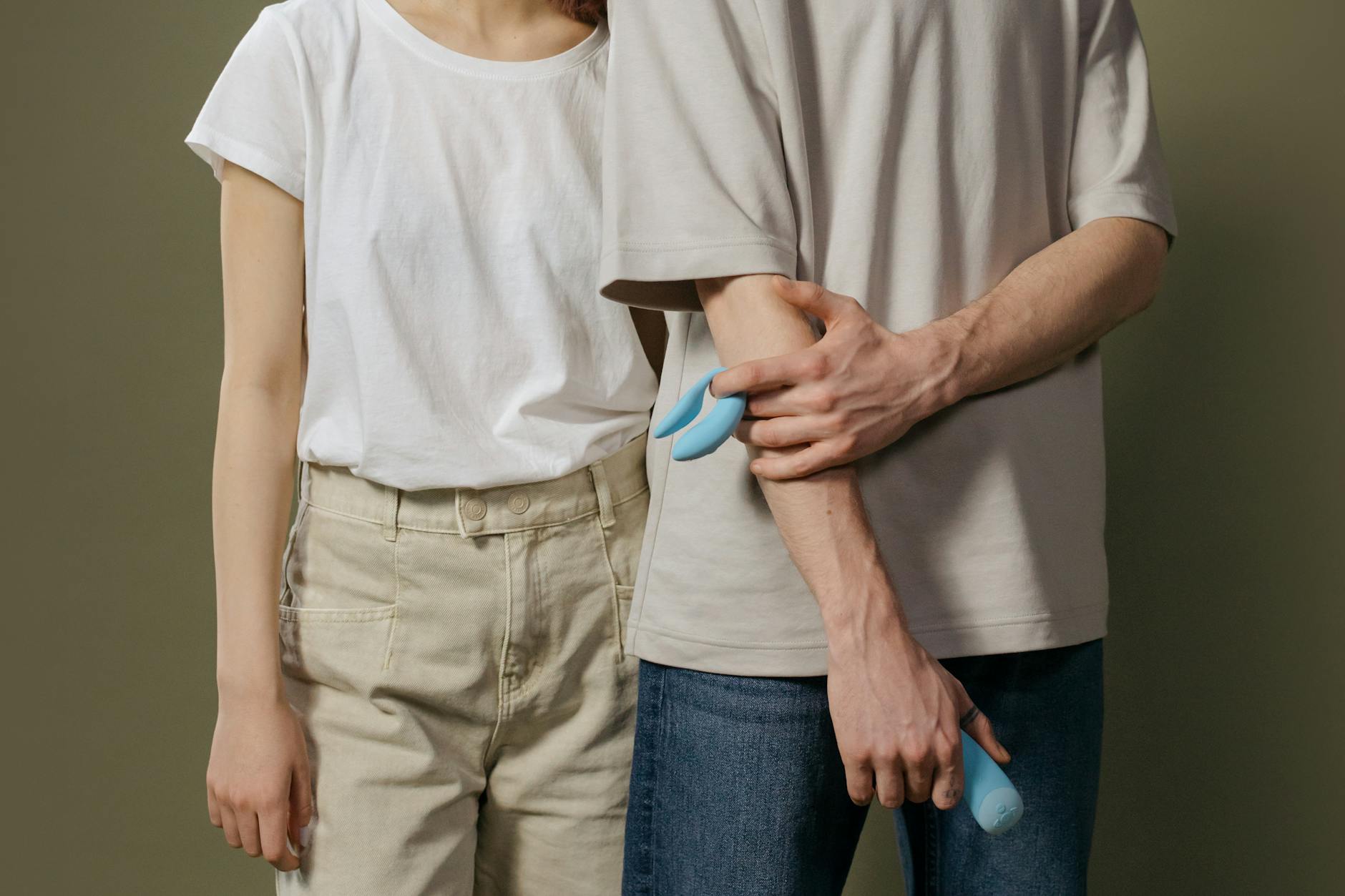 A couple standing together indoors, holding a lemon vibrator together, symbolizing modern intimacy and shared pleasure.